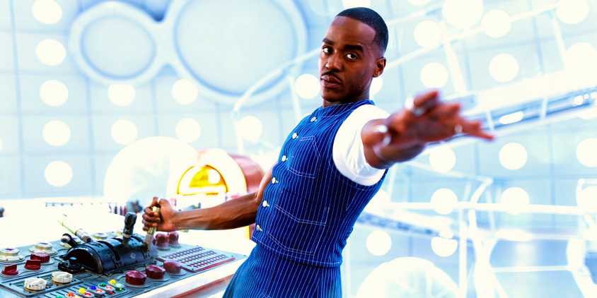 Ncuti Gatwa as the Fifteenth Doctor standing in the TARDIS reaching out his hand