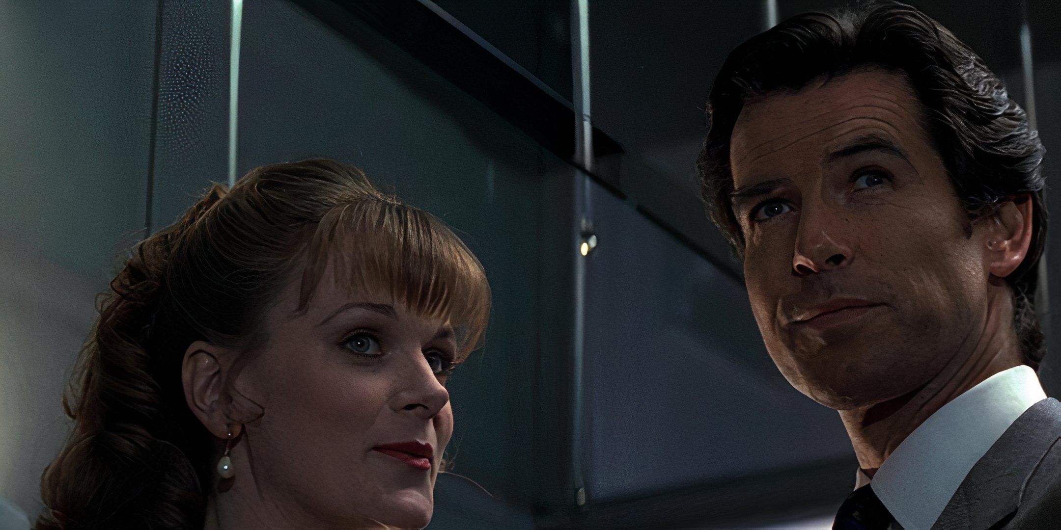 Samantha Bond and Pierce Brosnan smile and look off into the distance. 