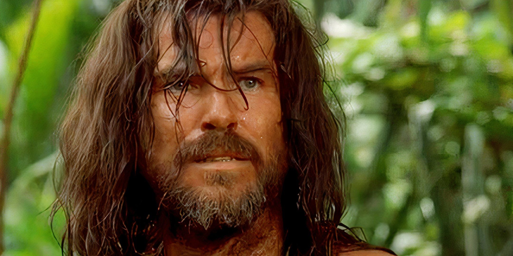 Pierce Brosnan with a beard and long hair in Robinson Crusoe