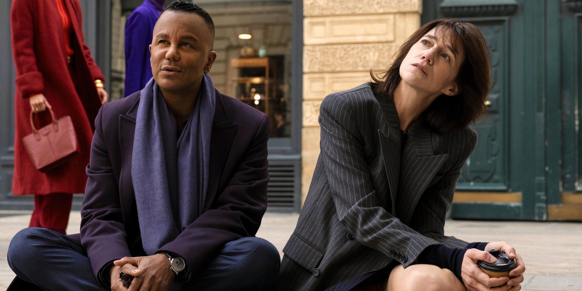 Raphael and Genevieve sit on the ground outside of the theater in Etoile season 1