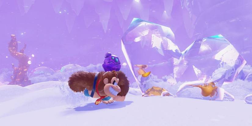 Donkey Kong runs across a snowy field with a rock companion in Donkey Kong Bananza.