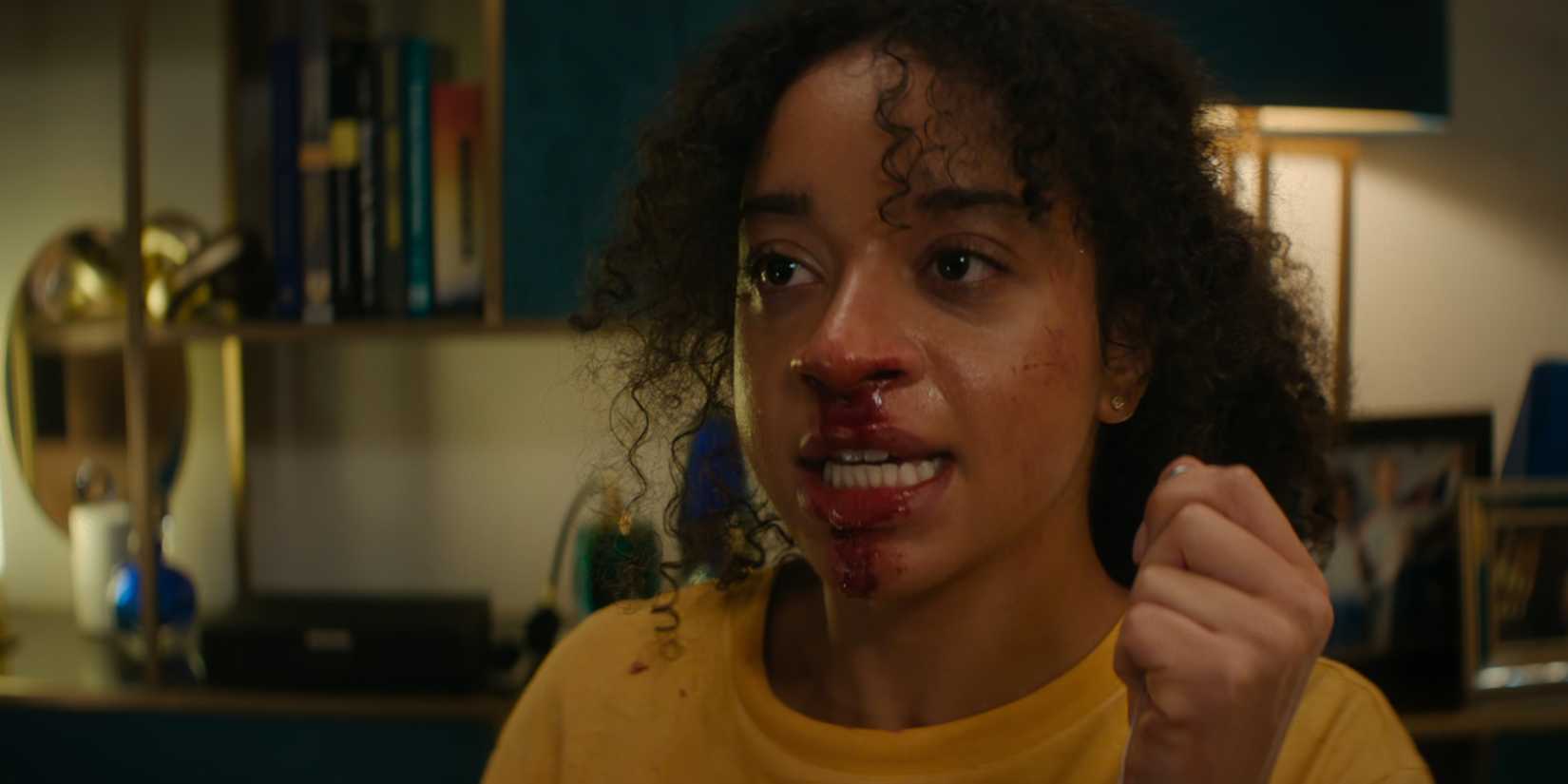 Siena Kelly as Maria holding Verity's pendant while blood drips from her nose in Black Mirror Bete Noire