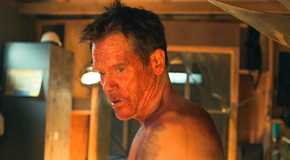 Hub Halloran (Kevin Bacon) with his face splattered in blood, looking over his shoulder in The Bondsman Season 1
