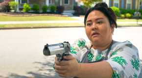 Midge (Jolene Purdy) aiming a gun, ready to fire in The Bondsman Season 1