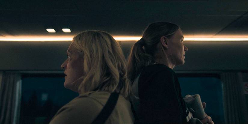 June (Elisabeth Moss) and Serena (Yvonne Strahovski) back to back, trying to protect themselves in The Handmaid's Tale Season 6 Ep 1