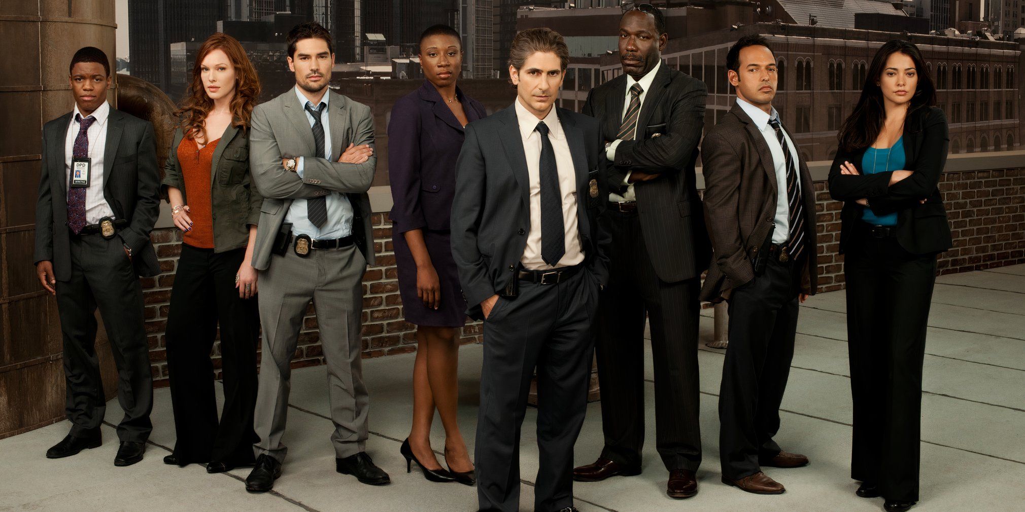 The original cast of Detroit 187 in front of brick and city buildings