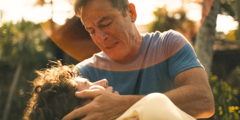 Timothy (Jason Isaacs) holding an unconscious Lochlan (Sam Nivola) in The White Lotus Season 3 Ep 8