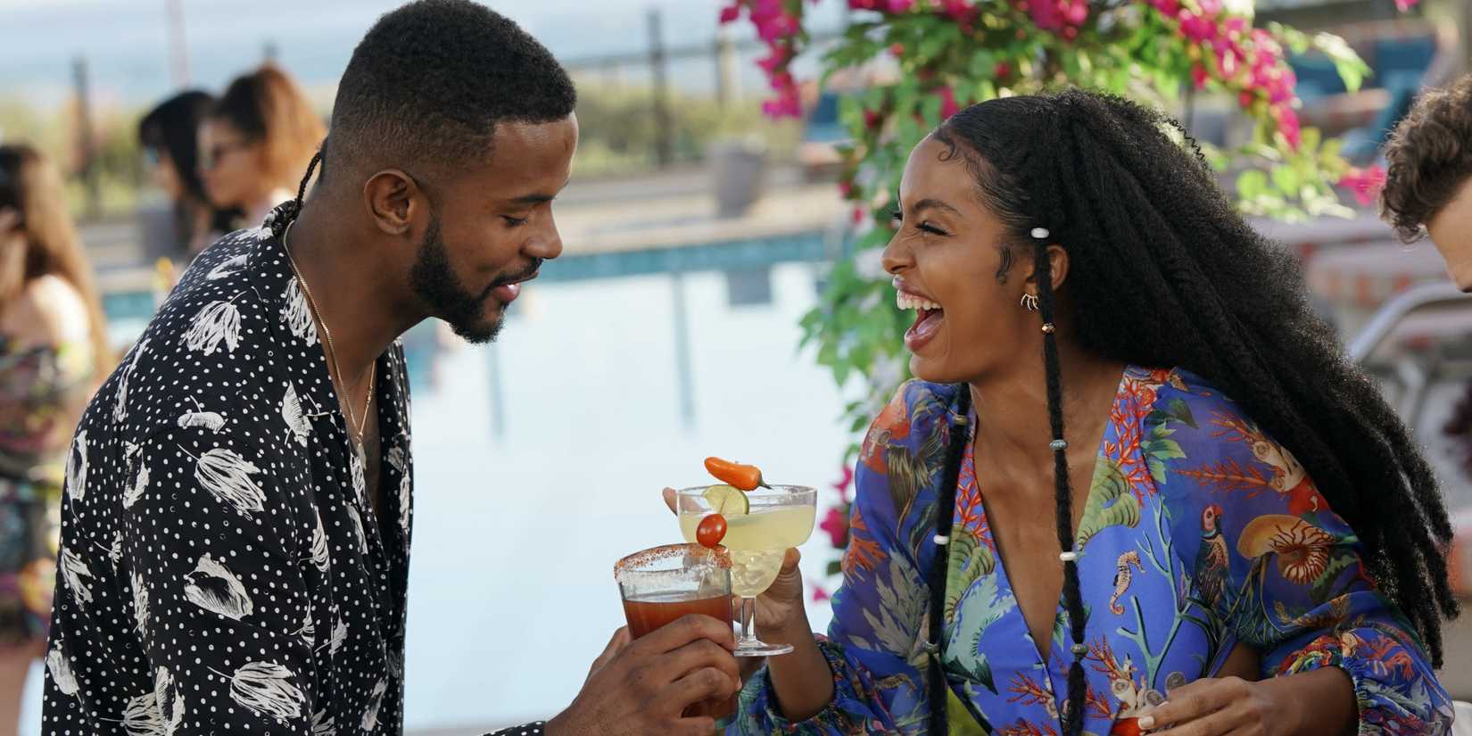 Trevor Jackson clinking glasses with a laughing woman in Grown-ish