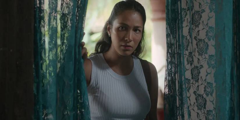 Trinidad Gonzalez in The Secret of the River between two blue curtains