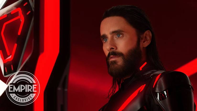 Jared Leto starring intensely to one side in a red and black suit in Tron: Ares