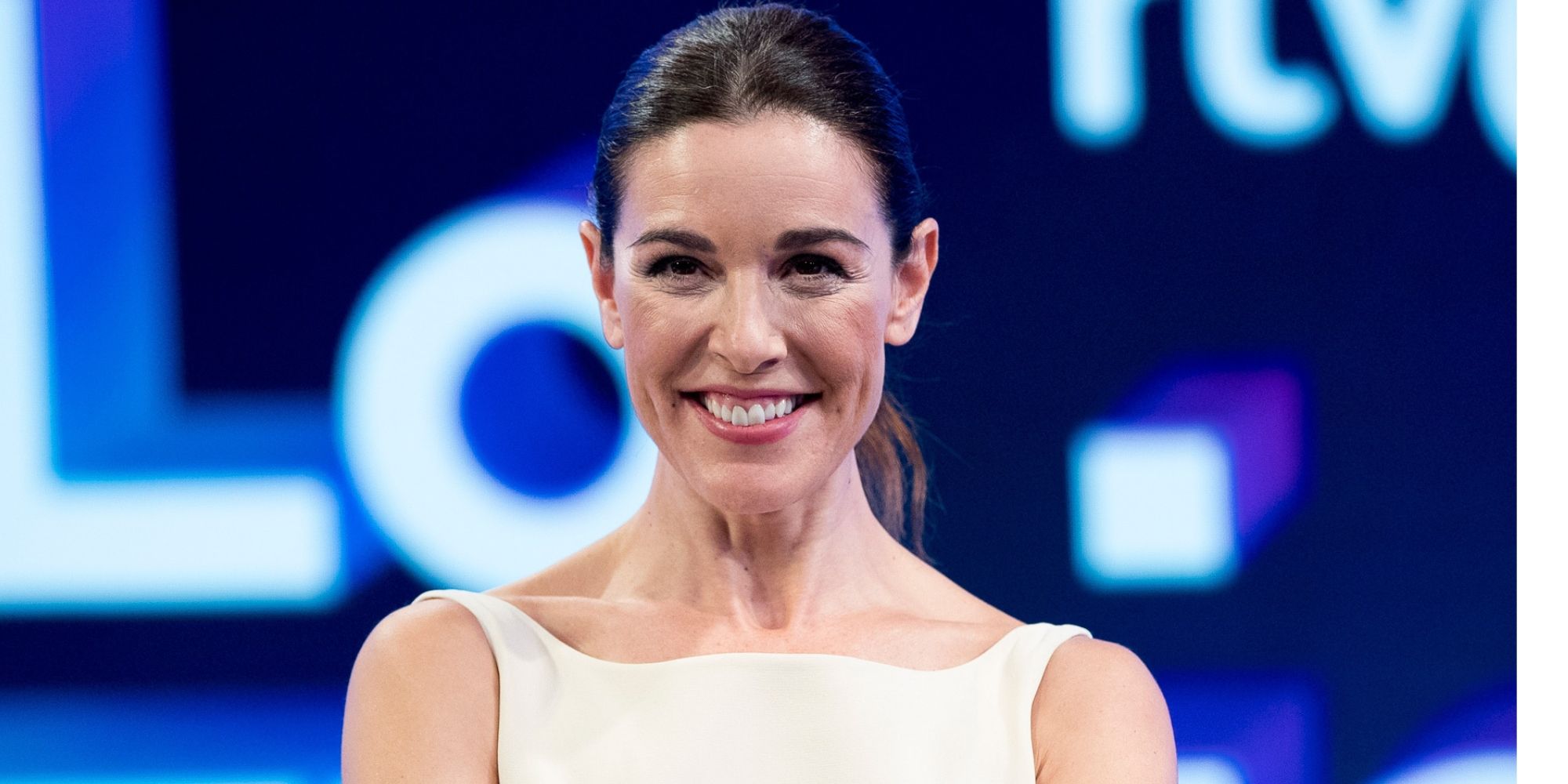 Raquel Sanchez-Silva smiling with hair pulled back and wearing a white top
