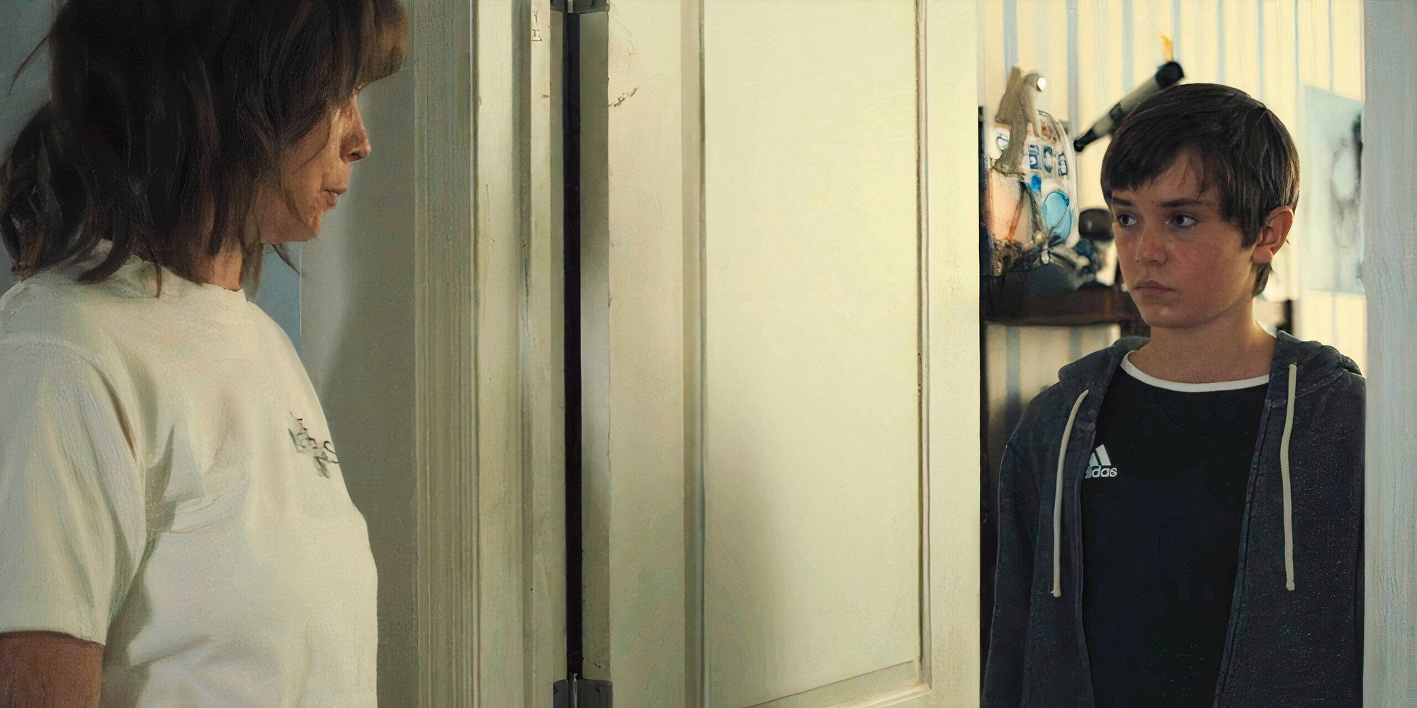 Ryan stands in a doorway talking to his mother, Lori Ross in Mare of Easttown