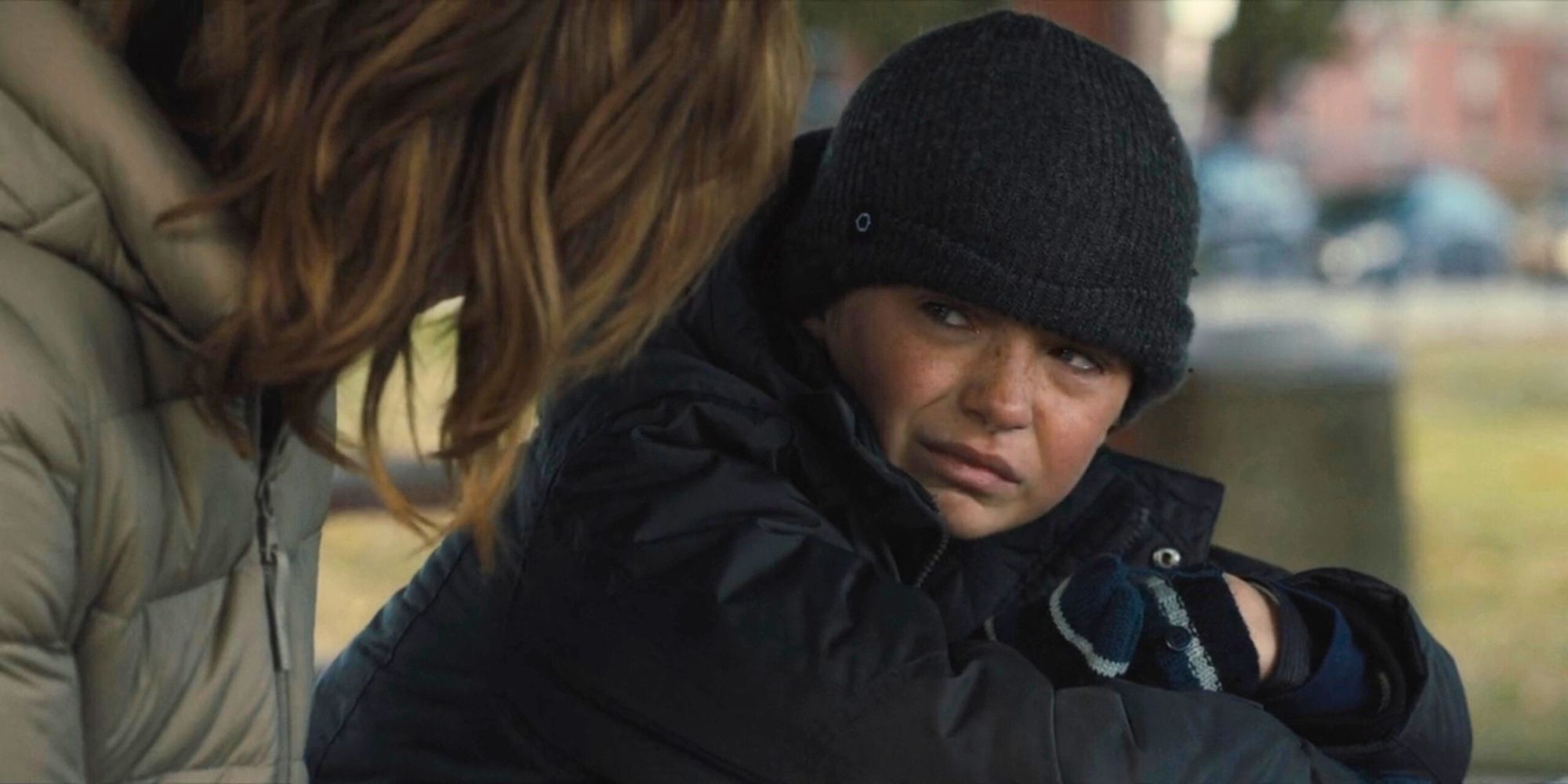 Ryan looking distraught at his mother, Lori, wearing a black hat, jacket, and mittens