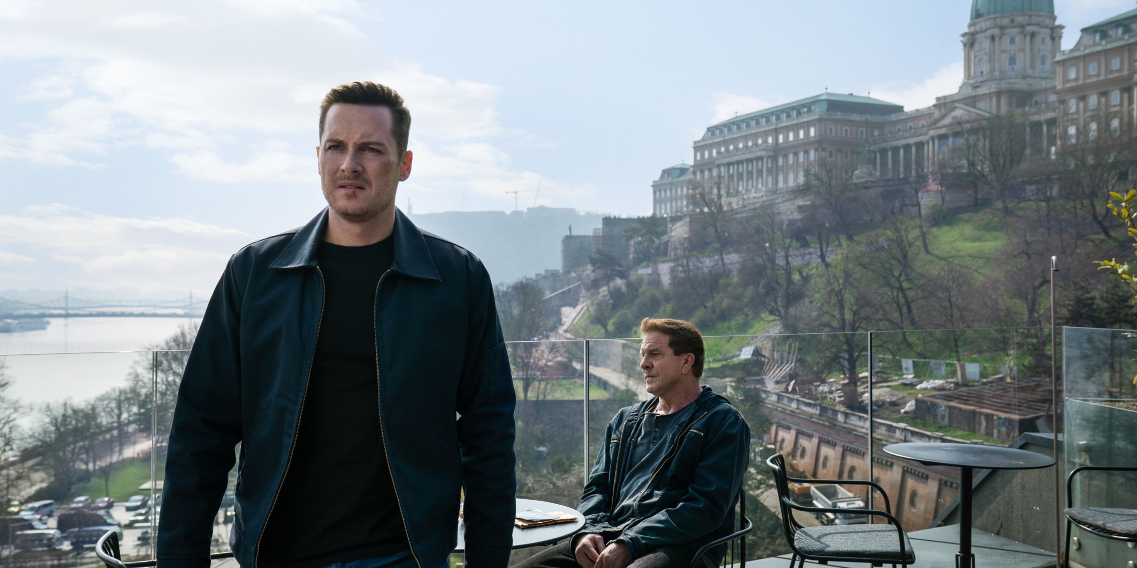 Wes walks away in FBI: International, leaving Dean sitting alone at a cafe overlooking the water in Budapest