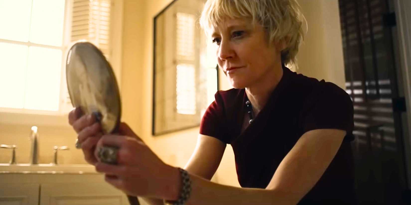 Anne Heche as Astrid holding a hand mirror in You're Killing Me