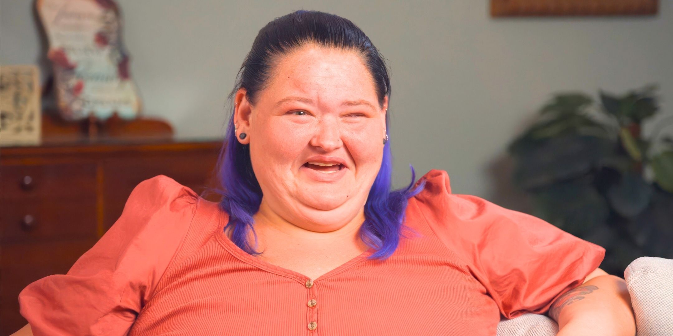 1000-Lb Sisters’ Amy Slaton smiles while sitting on a couch