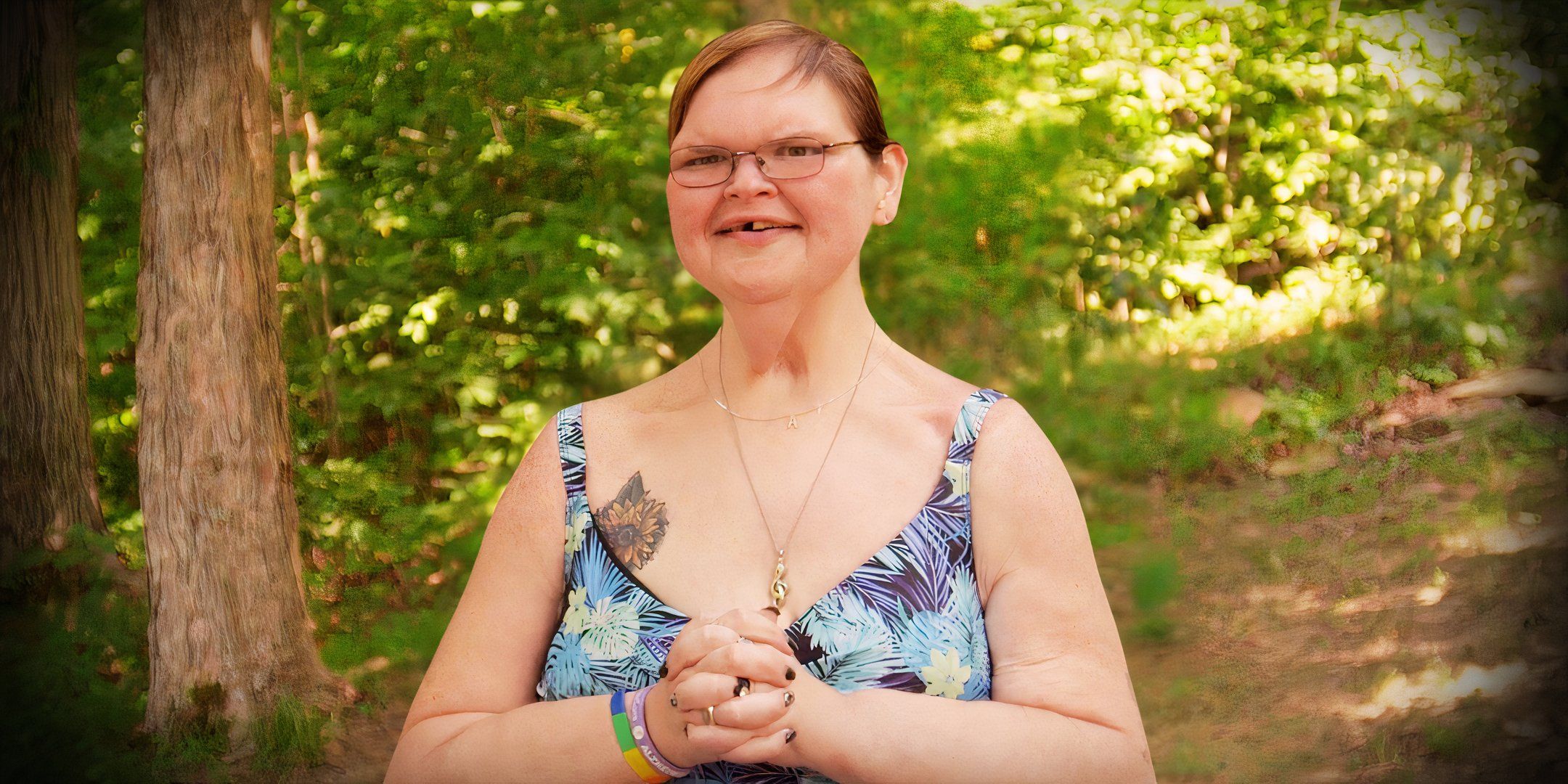 1000 lb sisters star tammy slaton in a blue print dress smiling with forest background