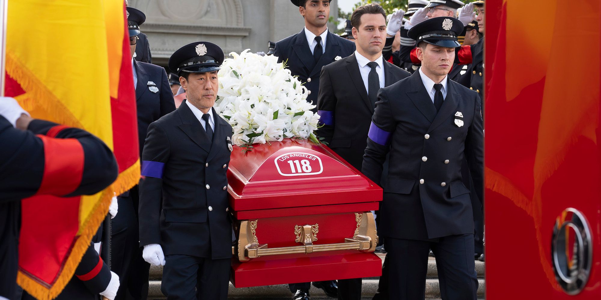 Chimney (Kenneth Choi), Ravi (Anirudh Pisharody), Eddie (Ryan Guzman), and Buck (Oliver Stark) carrying Bobby's coffin in 9-1-1 season 8, episode 16.