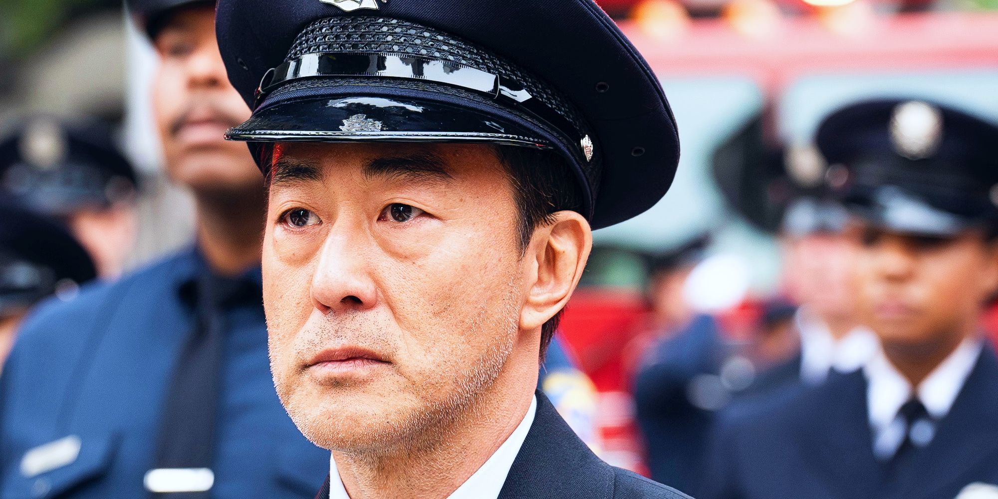 Kenneth Choi as Howard "Chimney" Han walking in Bobby's funeral procession in 9-1-1 season 8, episode 16.