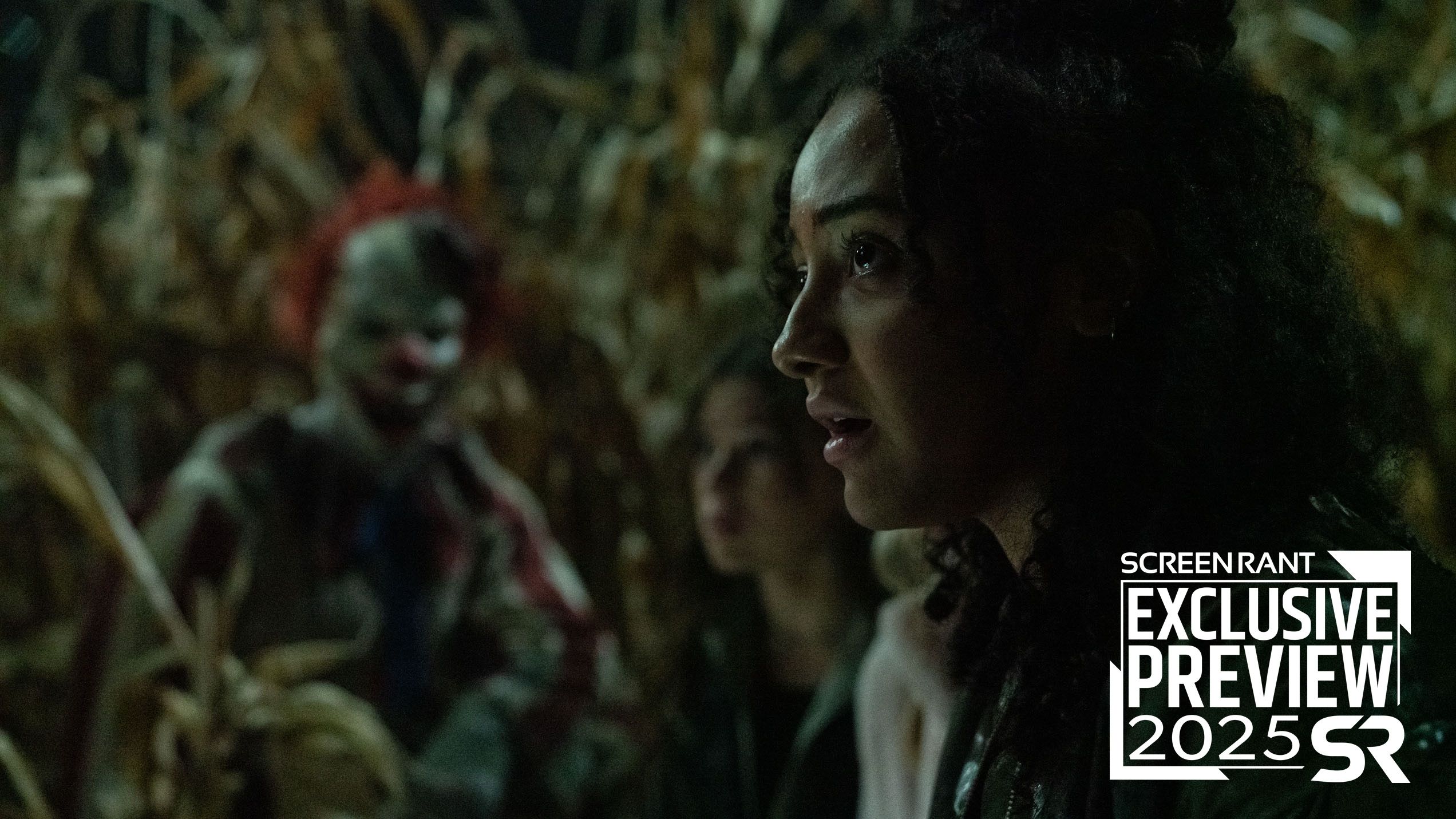 A scared girl in a cornfield with Frendo out of focus behind her in Clown in a Cornfield