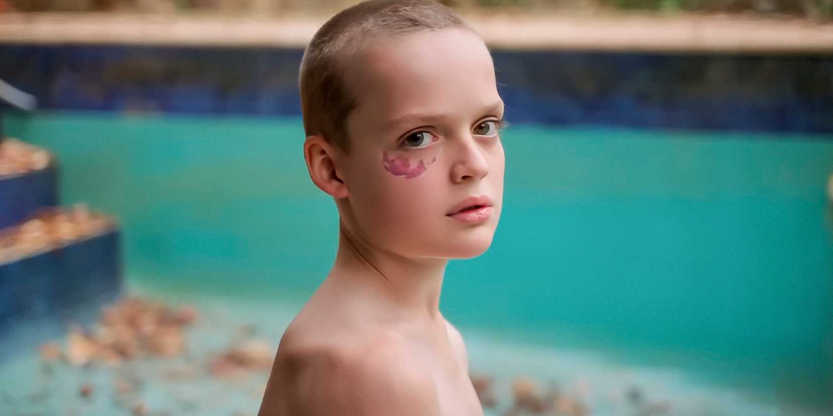 A child with a birth mark under his eye staring at the camera in Bring Her Back