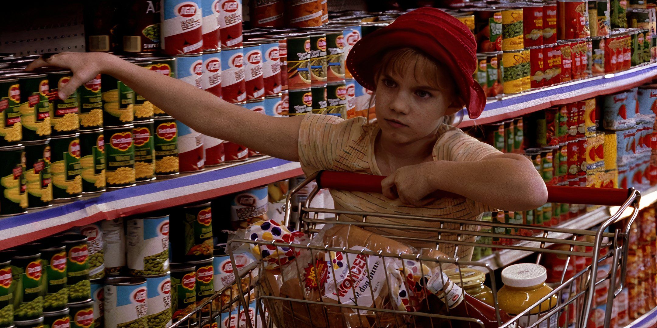 Anna Chlumsky grabs a can of vegetables from the grocery aisle and puts them in a shopping cart.