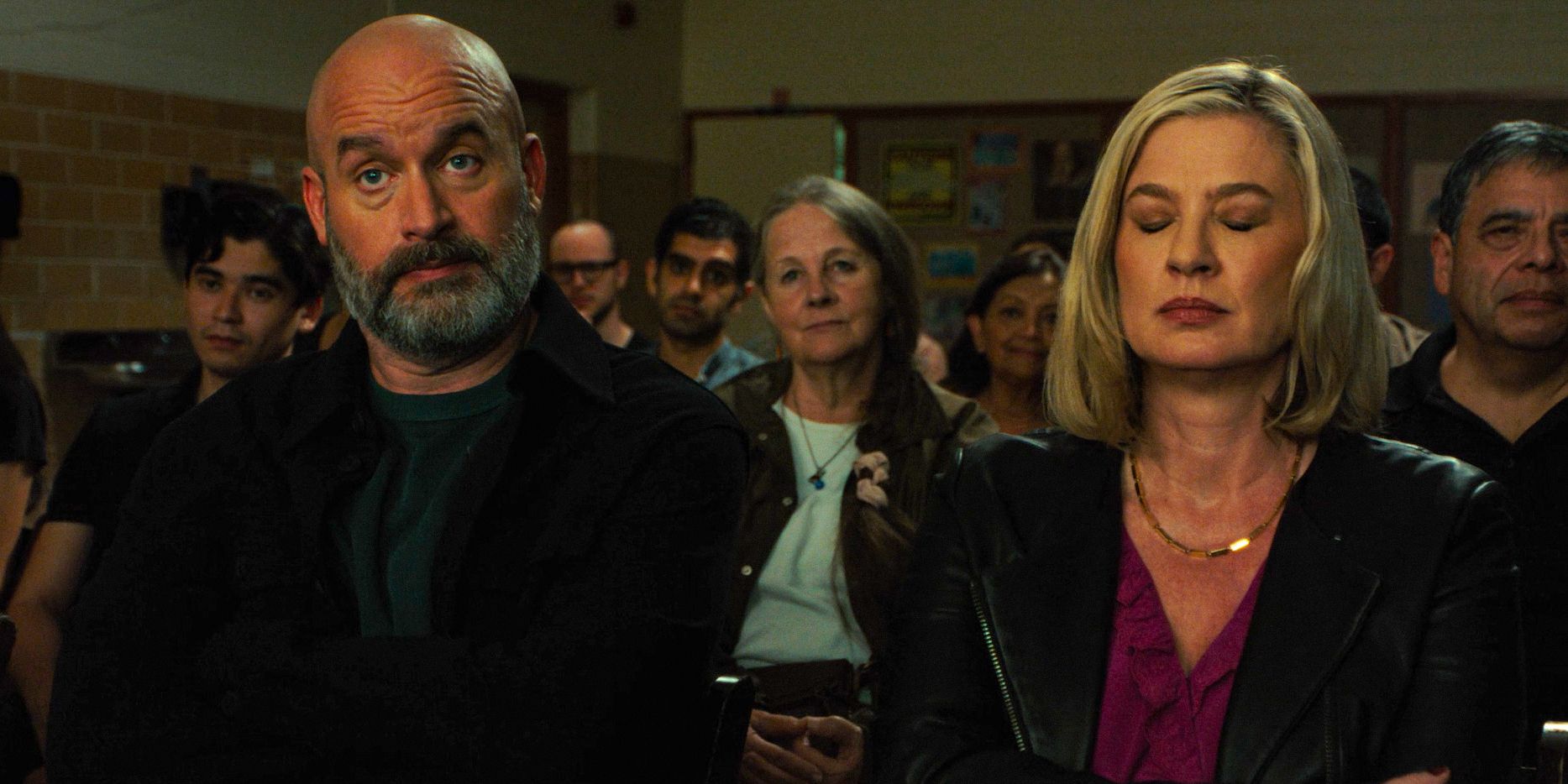 Character of Tom Segura and Christina (Christina Pazsitzky) with expressions watching a school performance in Bad Thoughts Season 1 Ep 3