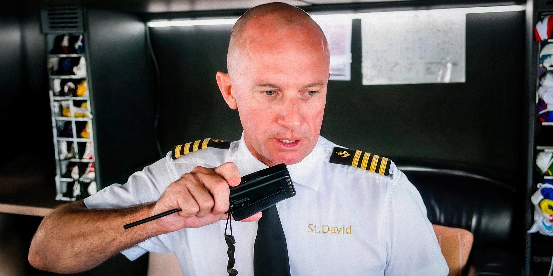 below deck star kerry kitheradge talking into a walkie talkie onboard in his uniform