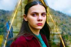 Dafne Keen as Lyra in His Dark Materials season 3 with a grassy landscape as the background