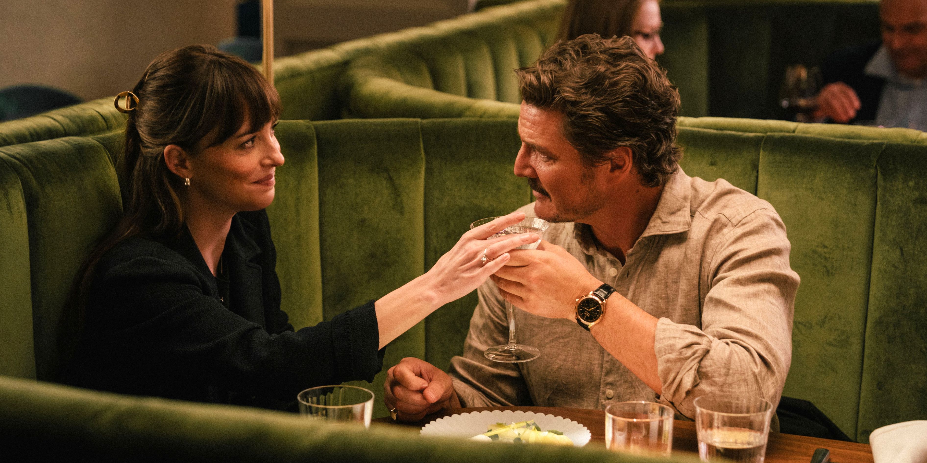 Dakota Johnson and Pedro Pascal looking warmly at each other on a date in Materialists