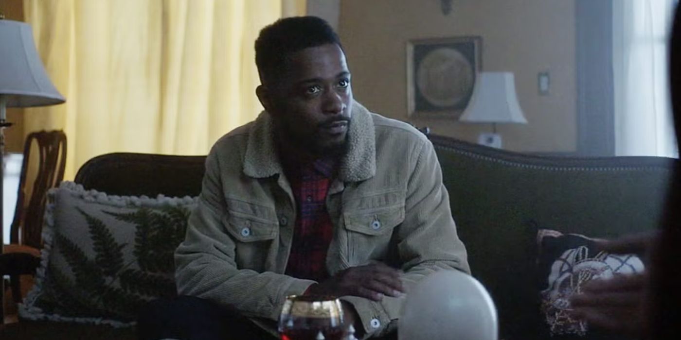 Darius (LaKeith Stanfield) sitting on a couch listening to someone in Atlanta.
