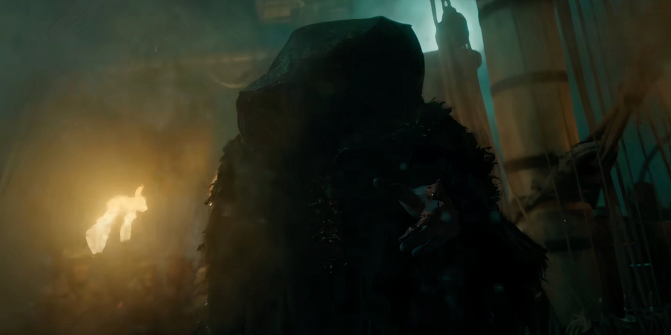 Frankenstein's Monster holding out his hand ominously in Guillermo del Toro's Frankenstein