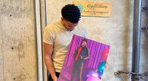 Jeremiah Brown from Love Island USA holding a photo of himself from a photoshoot.