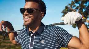 Jeremiah Brown from Love Island USA smiling in a golf photoshoot.