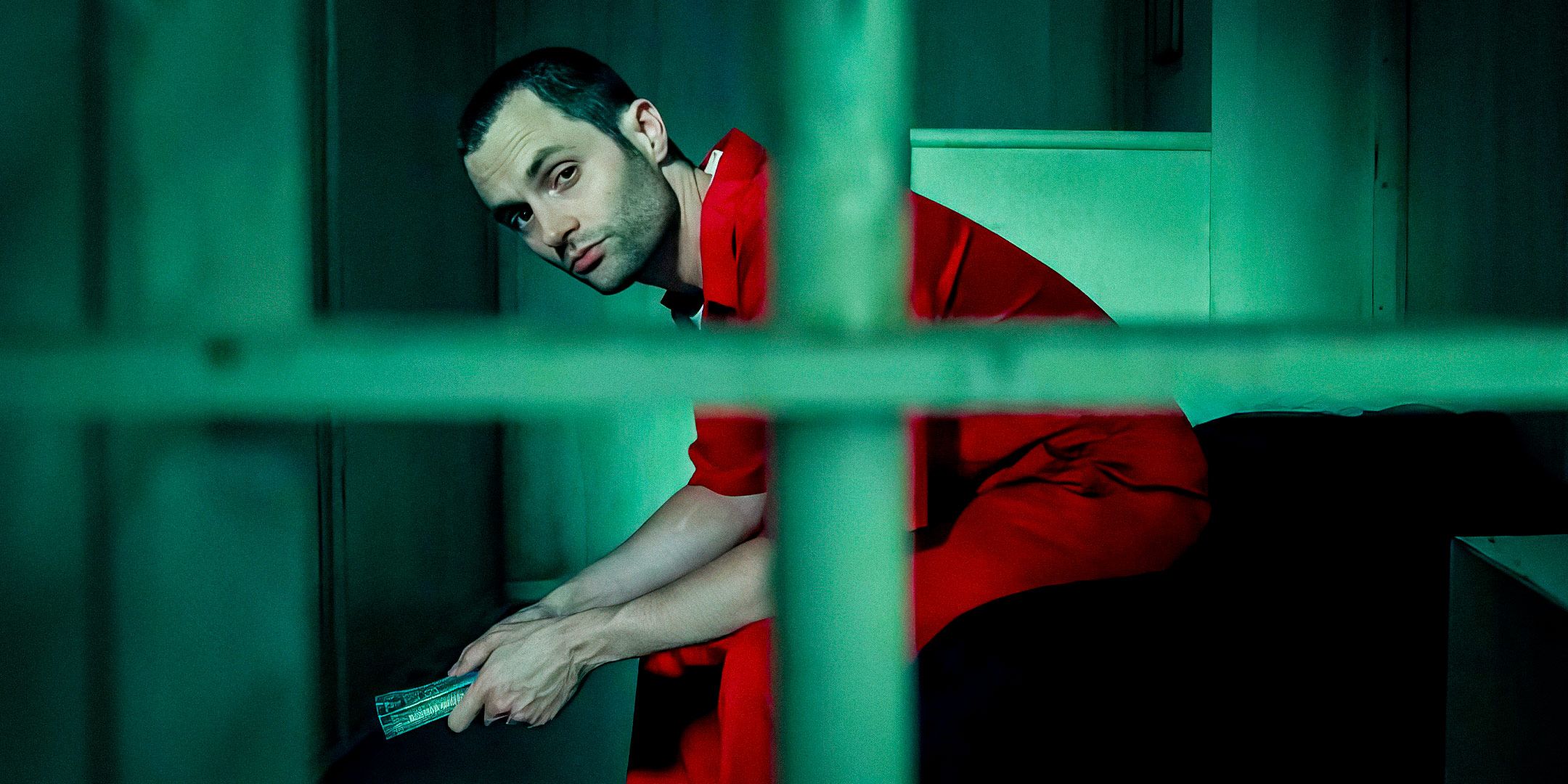 Penn Badgley como Joe Goldberg sentado en una cama detrás de las rejas de tu temporada 5