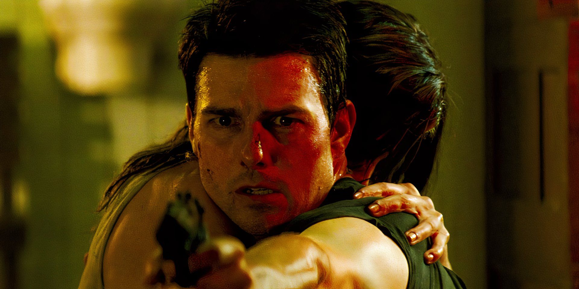 Ethan Hunt hugging Julia while pointing a gun outwards in Mission: Impossible III