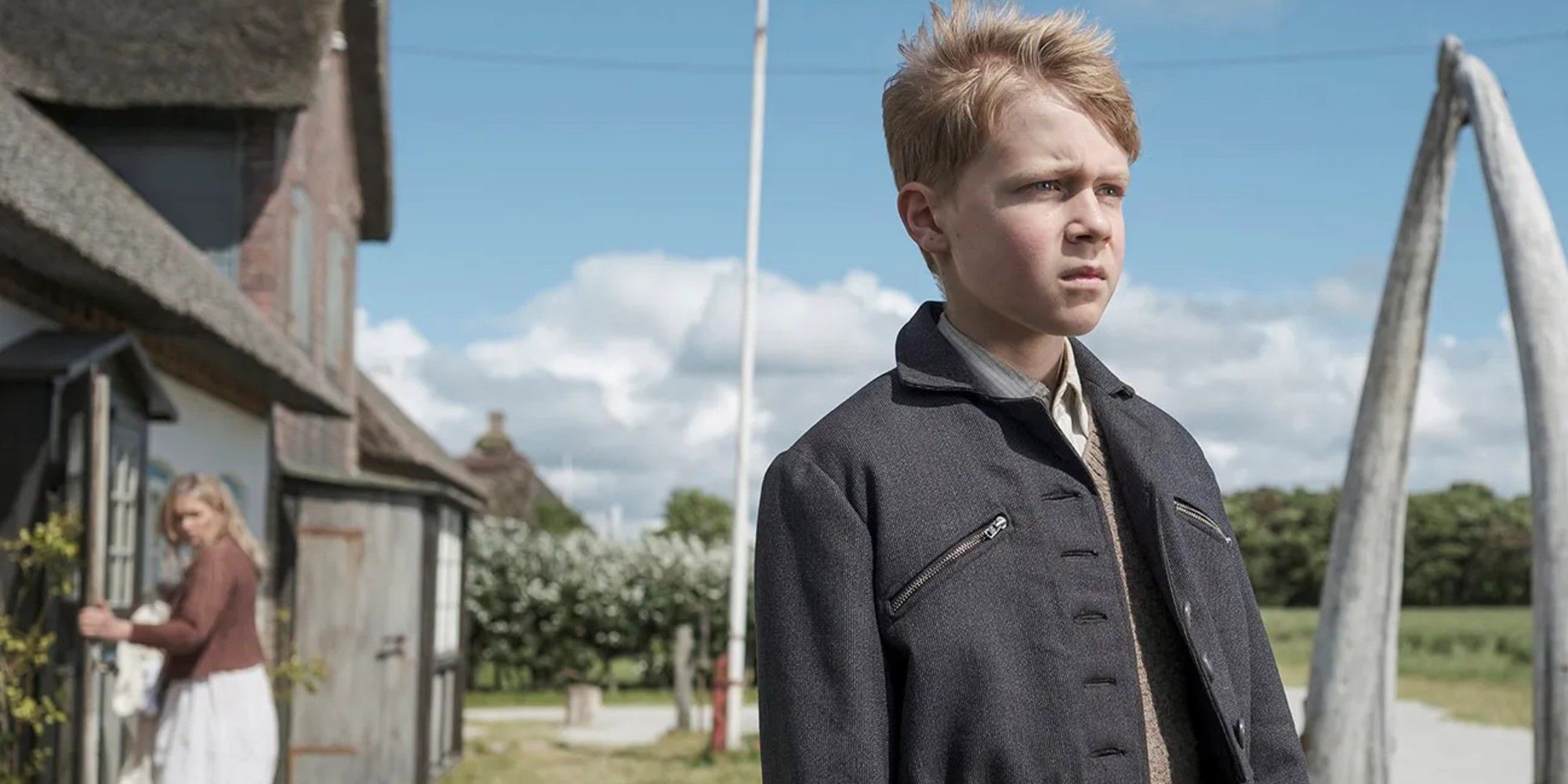 Nanning stands in front of his house while his mother walks through the front door in Amrum