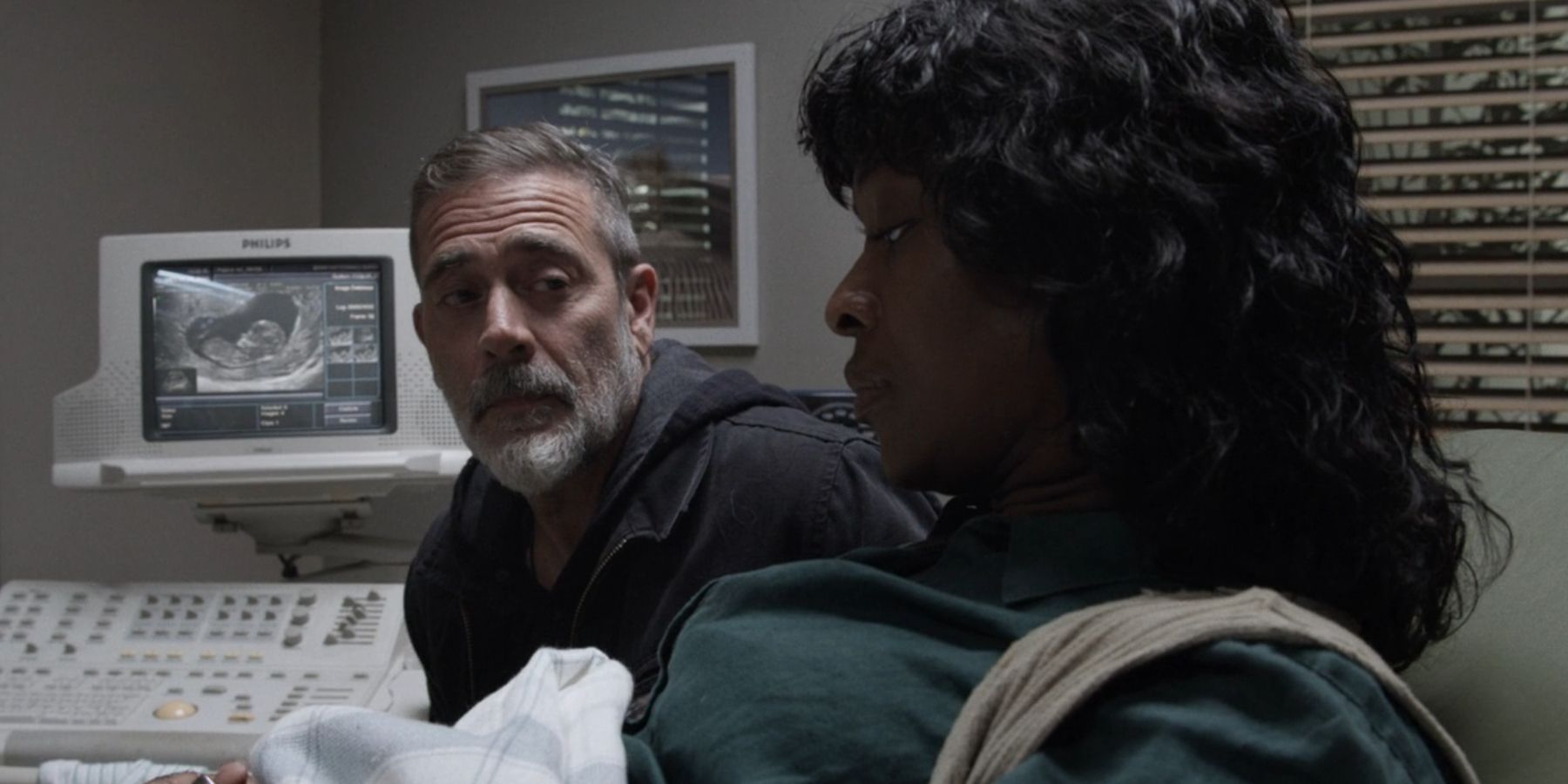 Negan (Jeffrey Dean Morgan) y Annie (Medina Senghore) con un ultrasonido de su bebé detrás de ellos en The Walking Dead