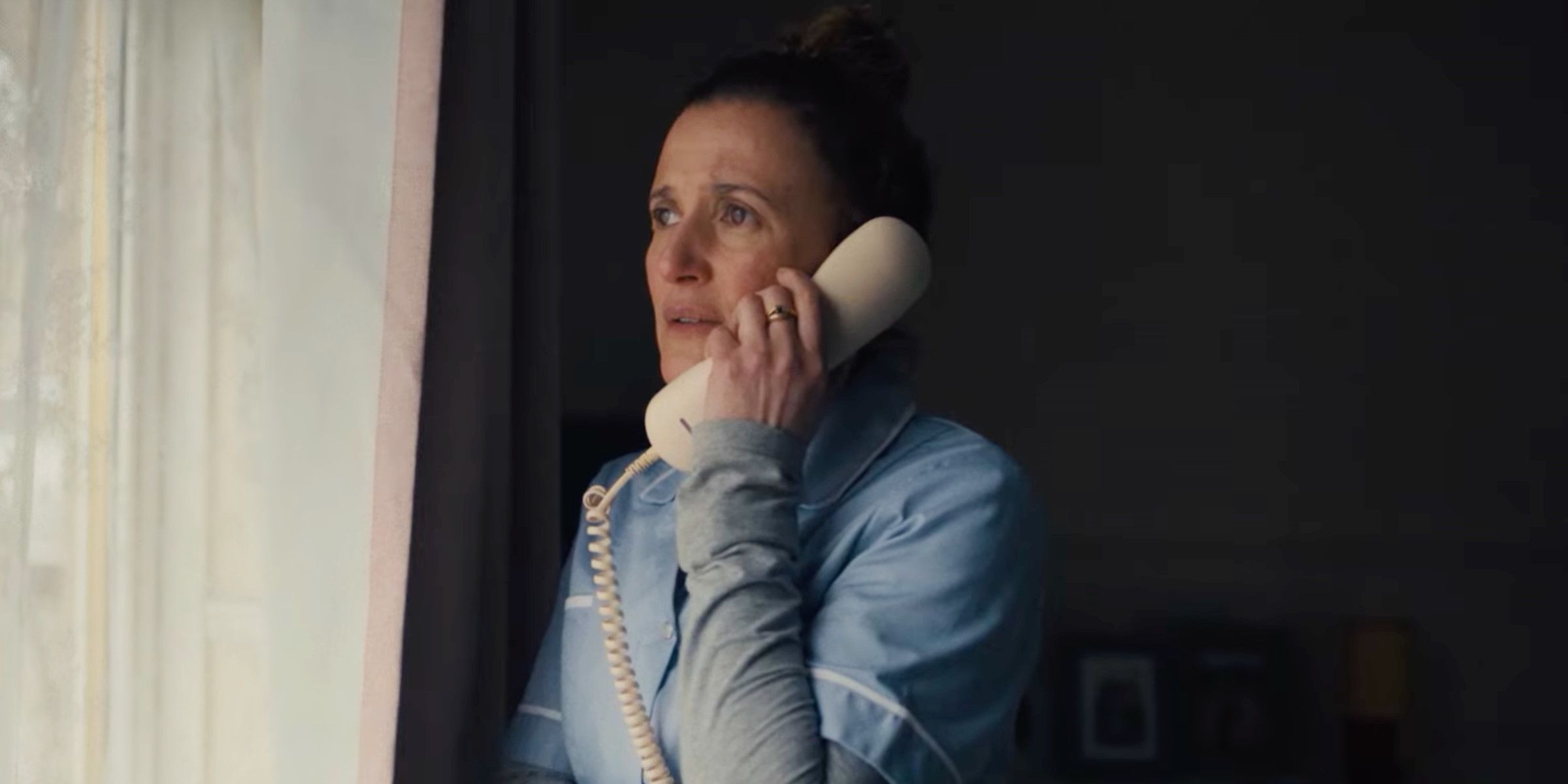 Restless Lyndsey Marshal on the phone looking out her window 
