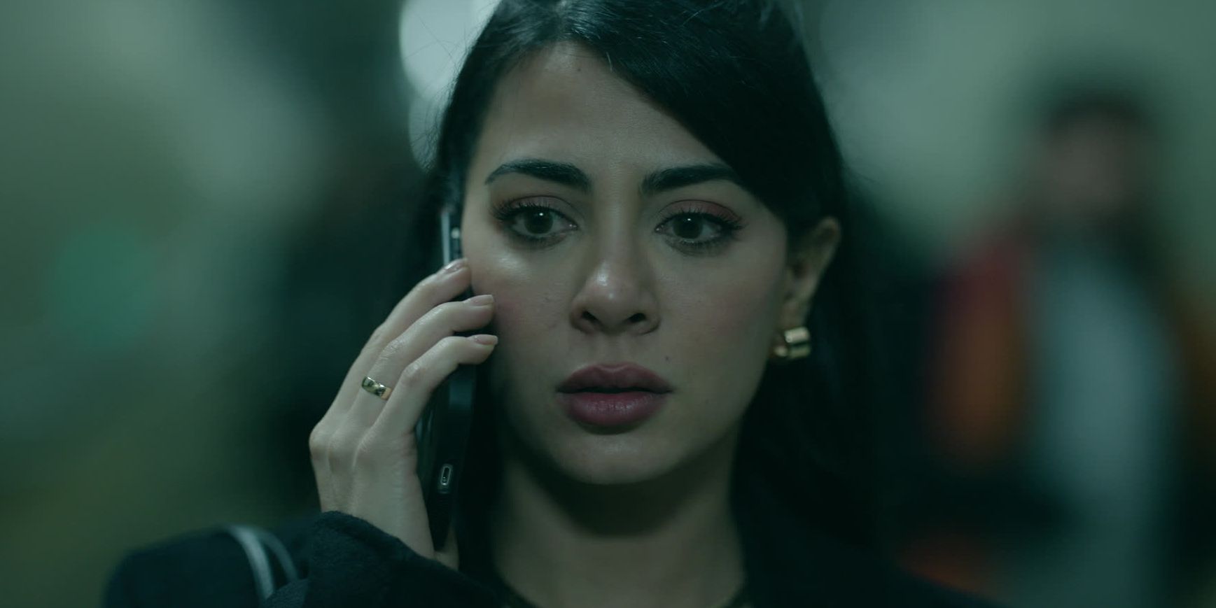 Rosario on the phone with a stunned expression in Rosario