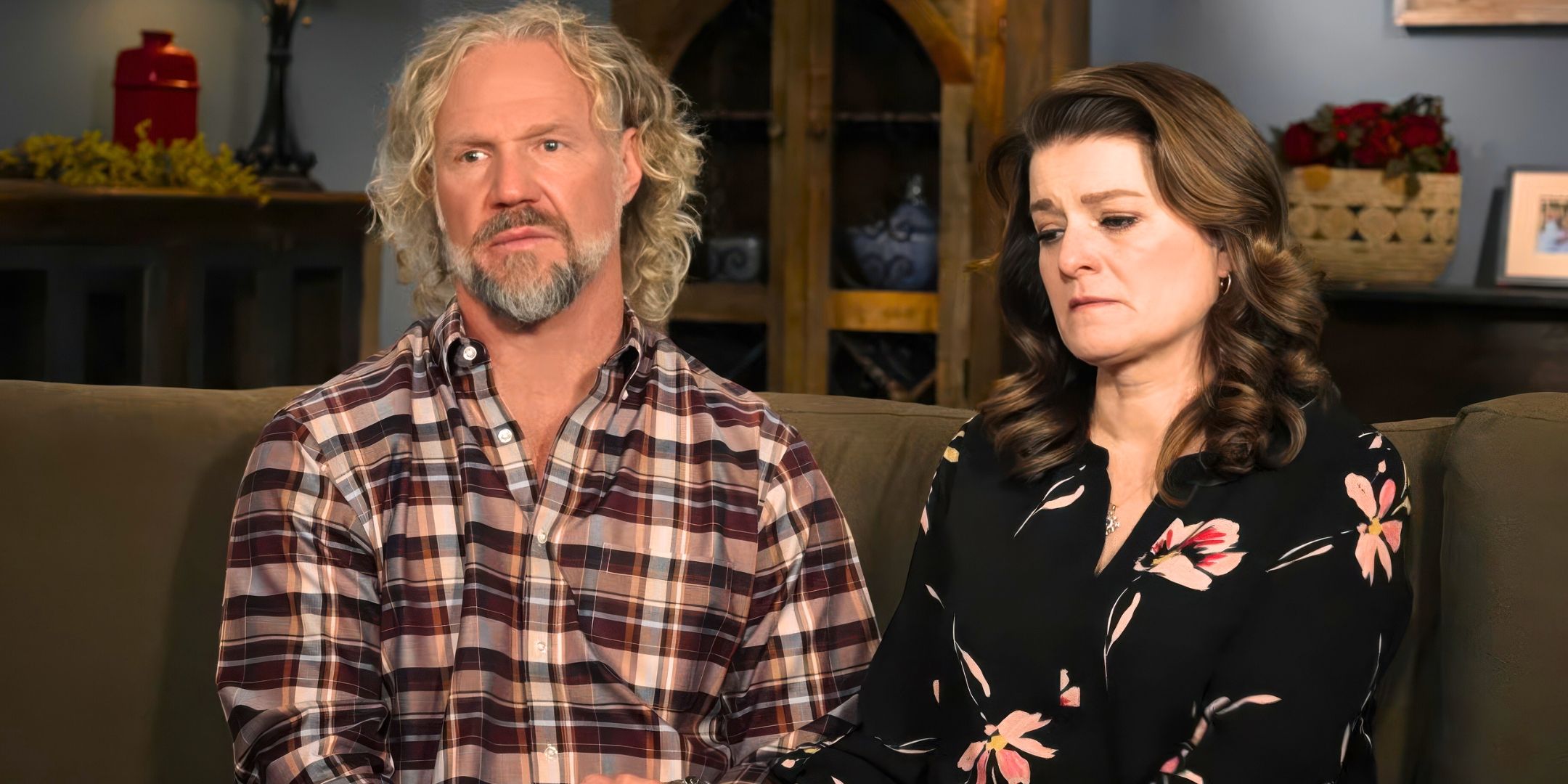 Sister Wives Kody & Robyn Brown sitting on a couch together looking upset