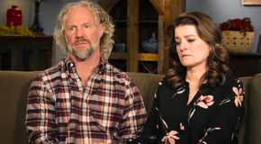 Sister Wives Kody & Robyn Brown sitting on a couch together looking upset