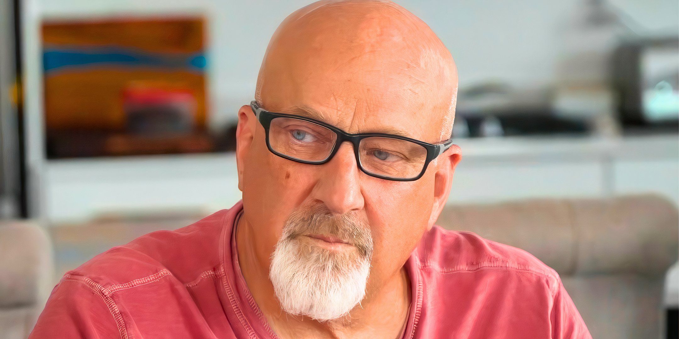 sister wives star david woolley in a red shirt with black framed eyeglasses looking serious