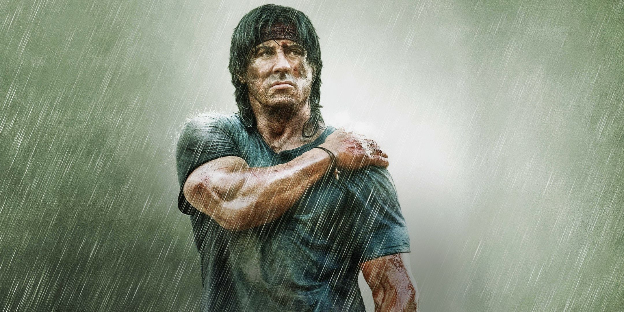 Sylvester Stallone holds his wounded shoulder in Rambo (2008)