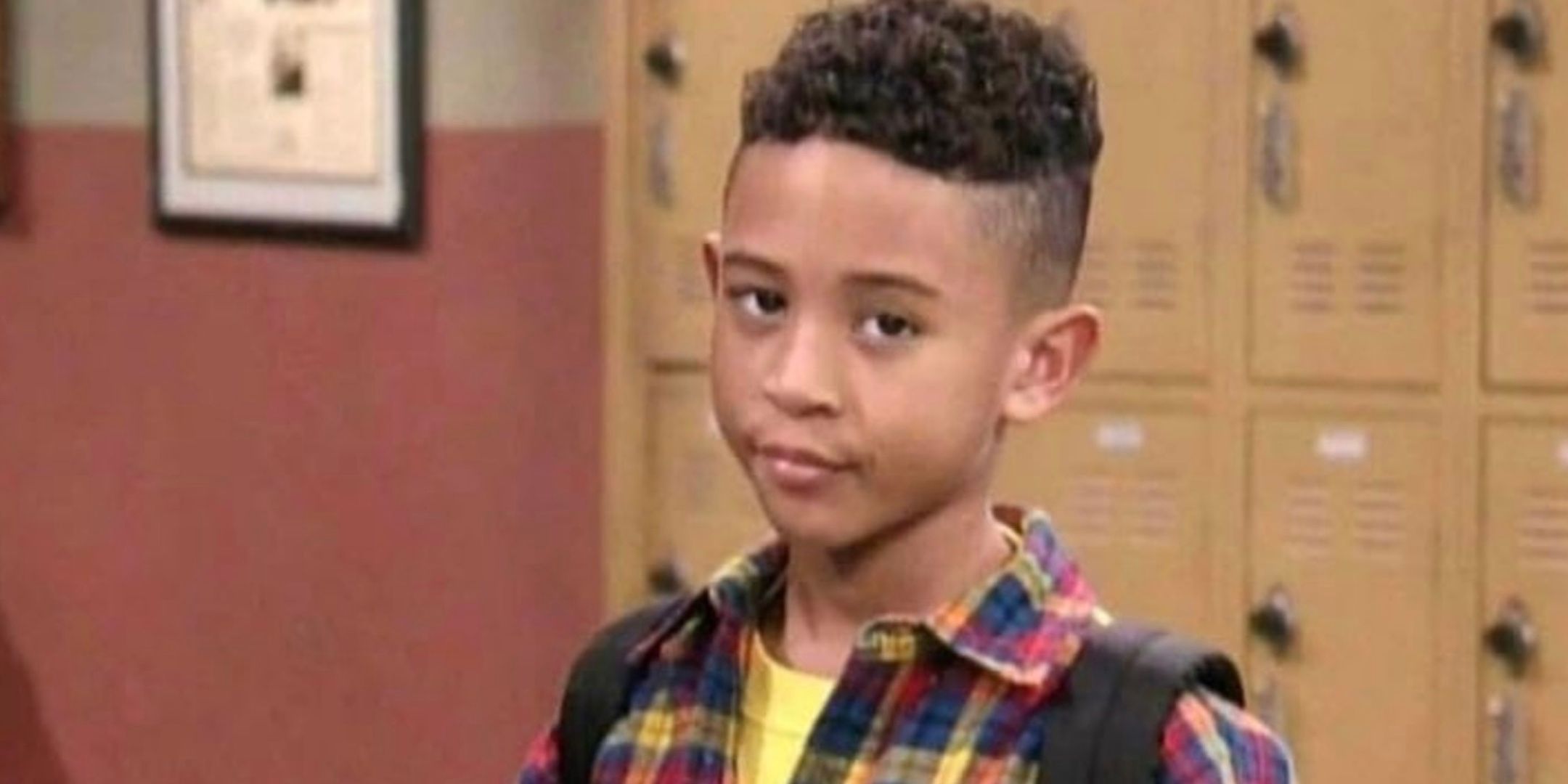 Tahj Mowry smirks while looking directly at the camera. 