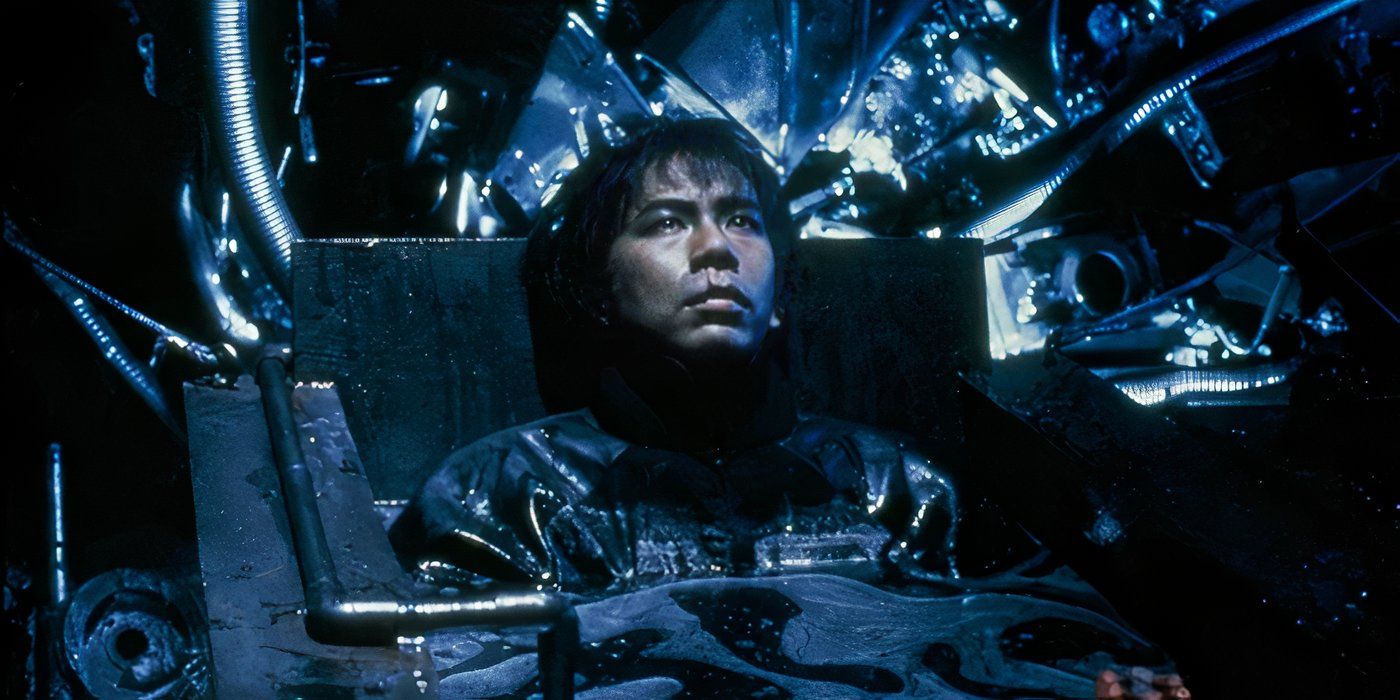 A man is submerged in a pool of dark liquid in Tetsuo II: Body Hammer