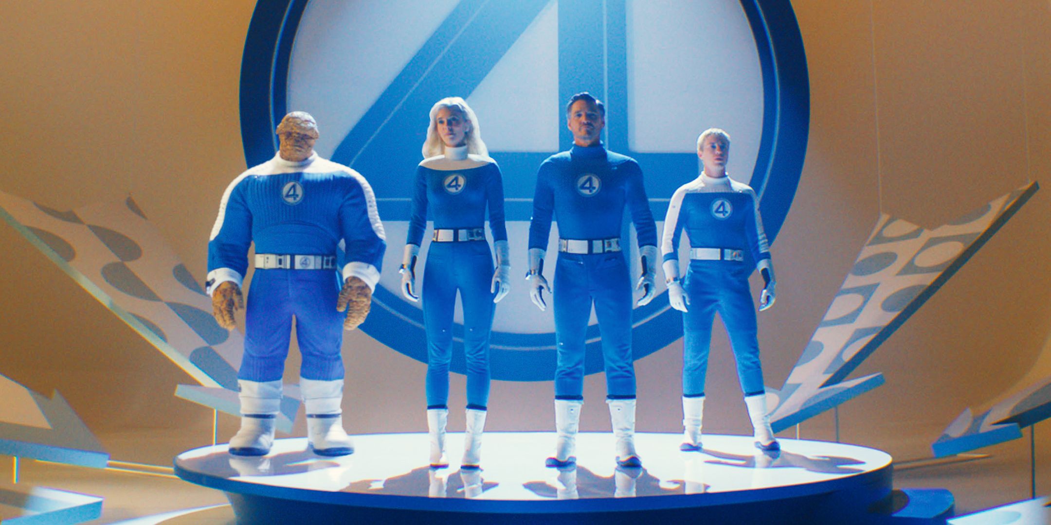 The Cast of Fantastic Four First Steps in Their Blue Uniforms Standing on a Stage