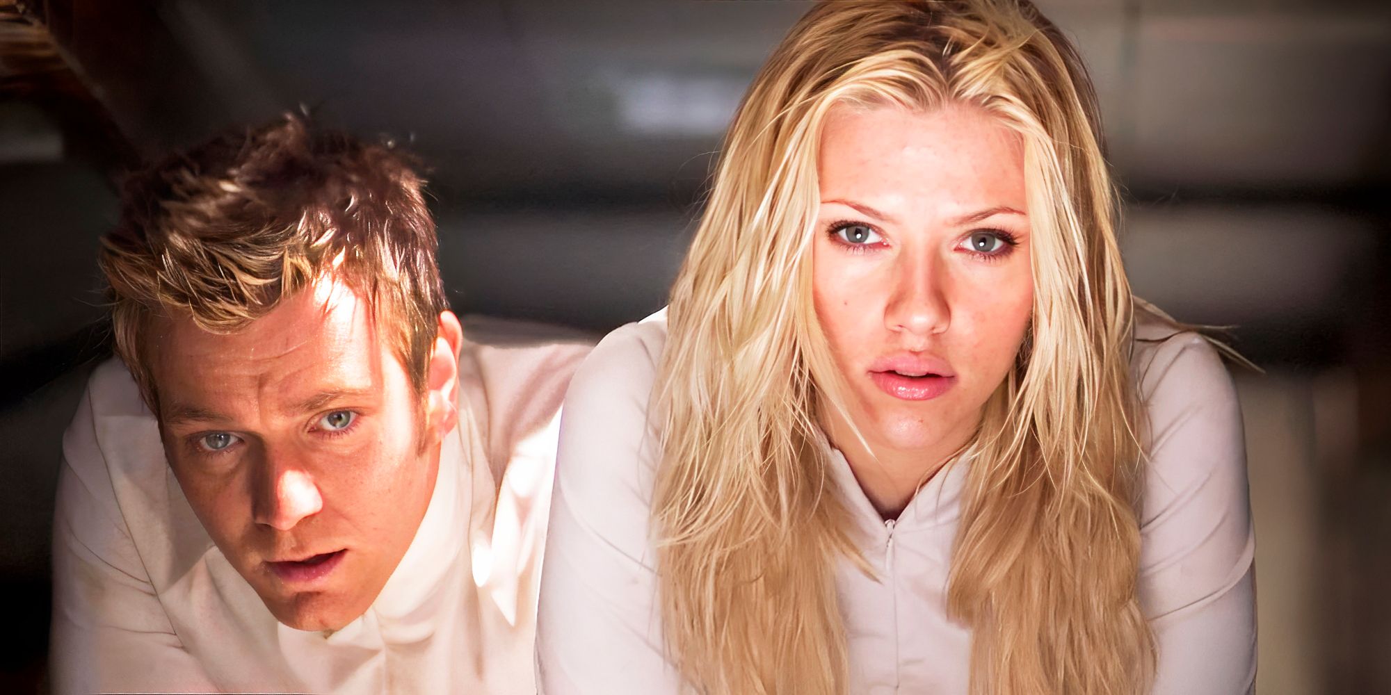 Ewan McGregor as Tom Lincoln kneeling beside Scarlett Johansson as Sarah Jordan in The Island.