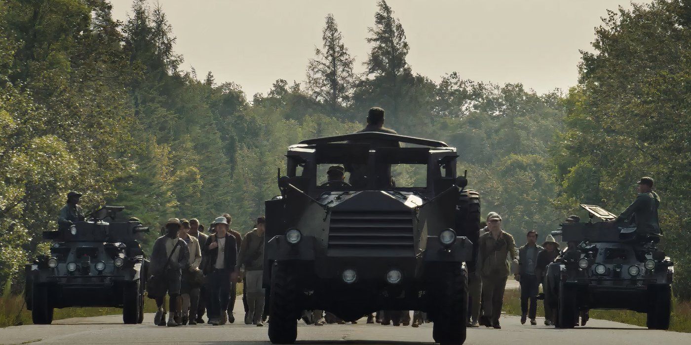 An army vehicle driving in front of a group of boys in The Long Walk