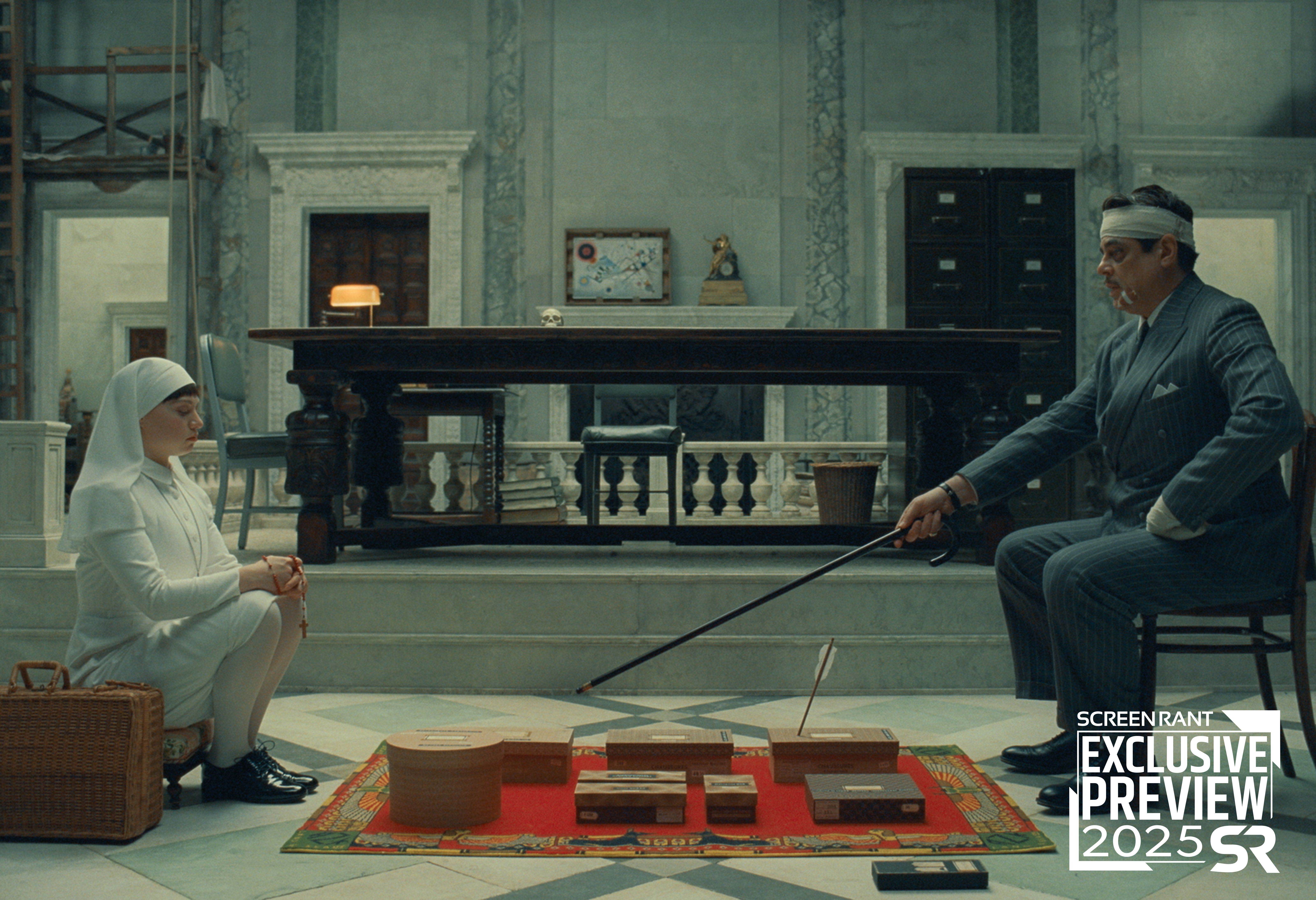 A father and daughter duo are across from each other in The Phoenician Scheme Still ScreenRant Exclusive